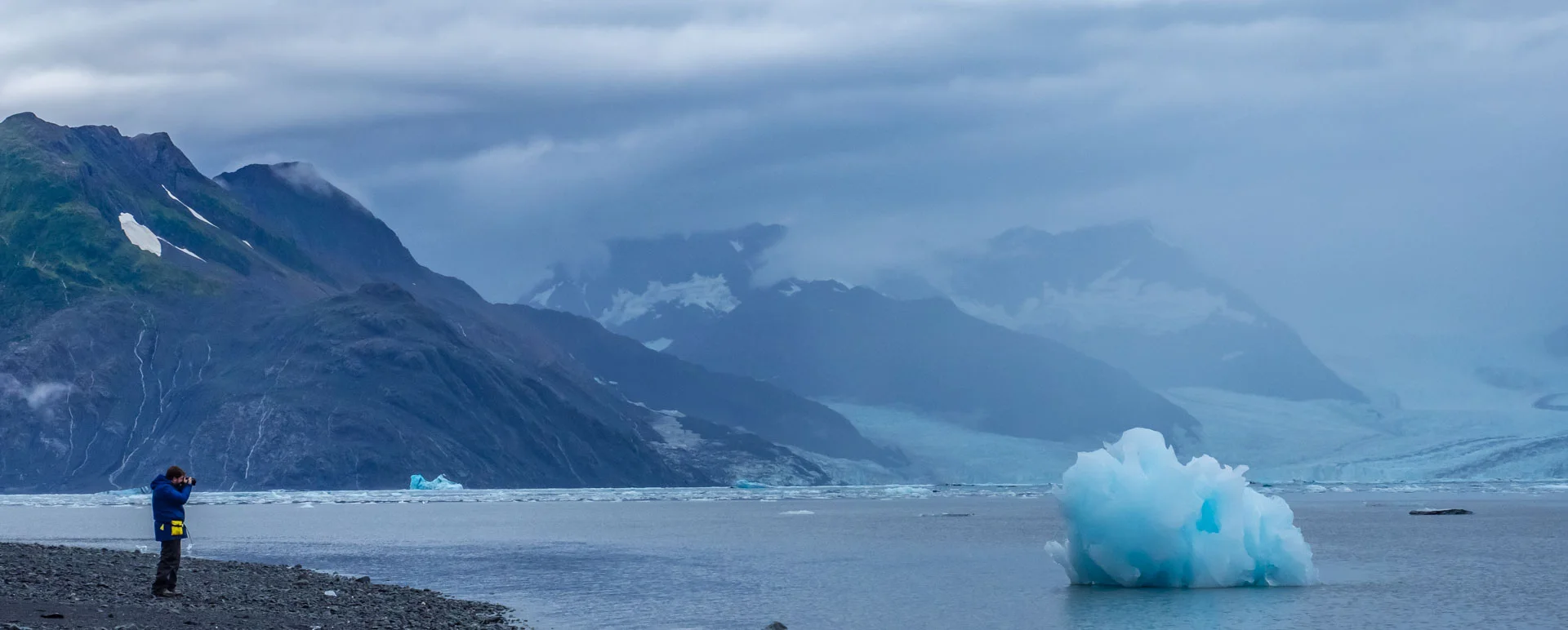Salvador Garza photographing an iceberg against a glacier landscape in Alaska