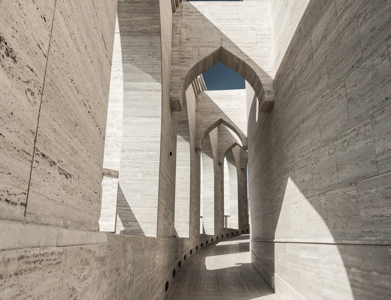 Sunlit geometric concrete passage at Katara