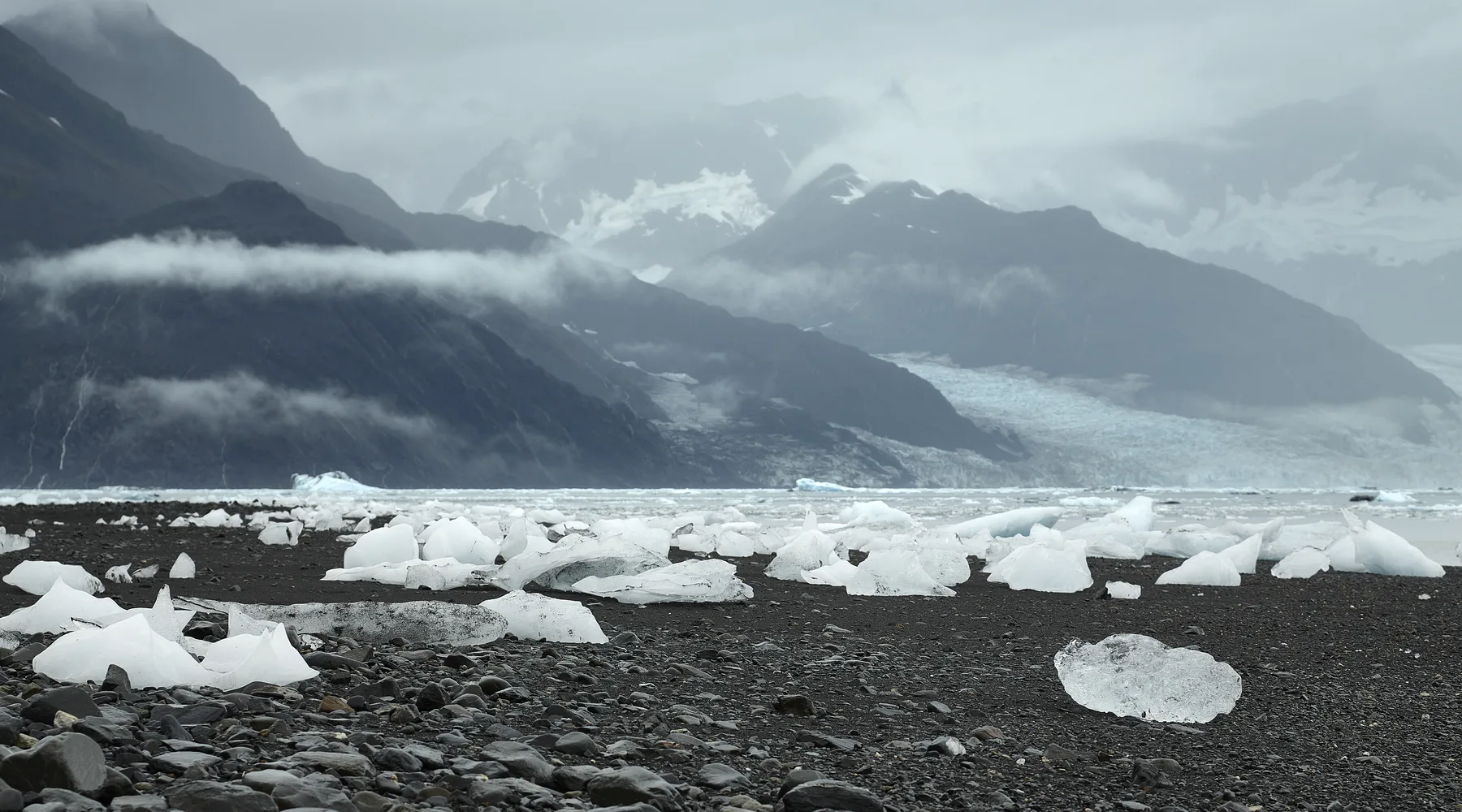 Glacier and scattered ice beneath misty mountains near Valdez, Alaska
