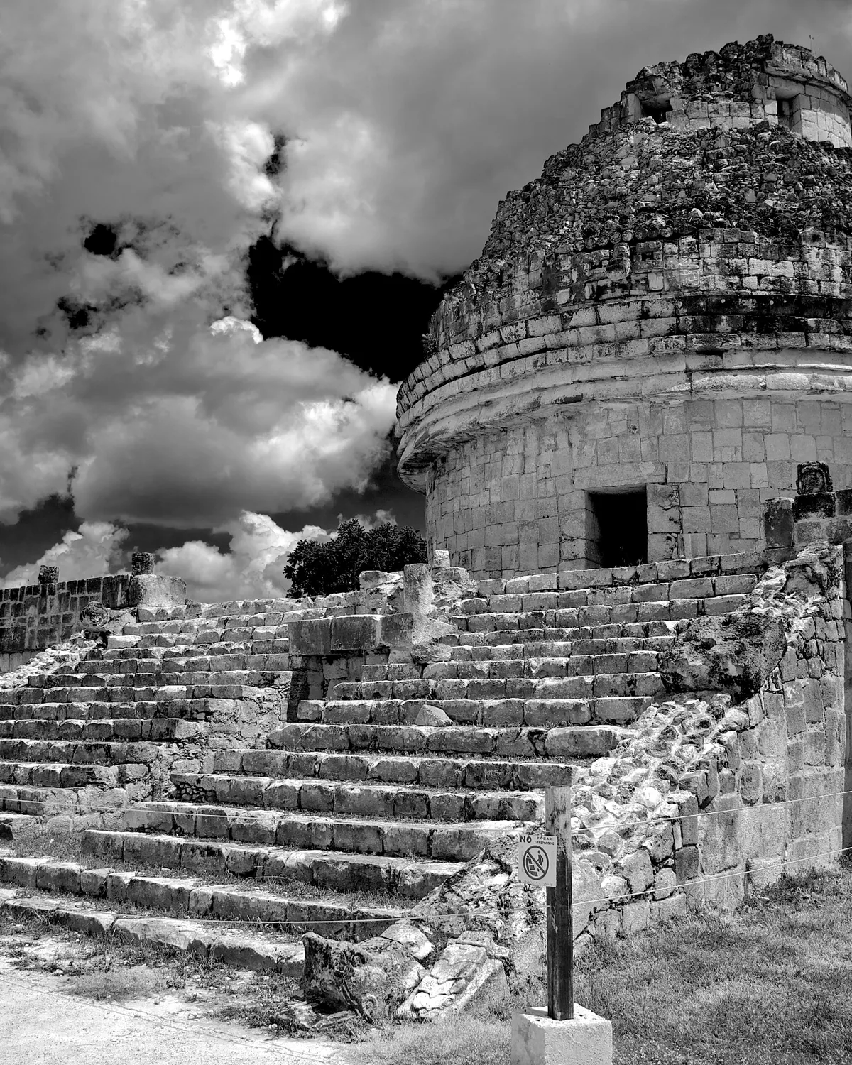 Historic stone structure beneath dramatic clouds in Yucatán